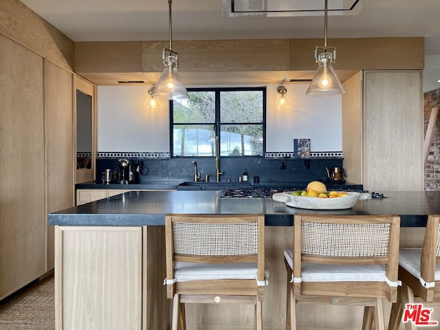 kitchen with decorative light fixtures and light brown cabinets