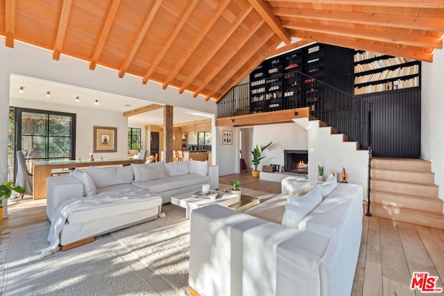 living room featuring plenty of natural light, beam ceiling, and wood ceiling