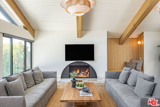 living room with vaulted ceiling with beams and wooden walls