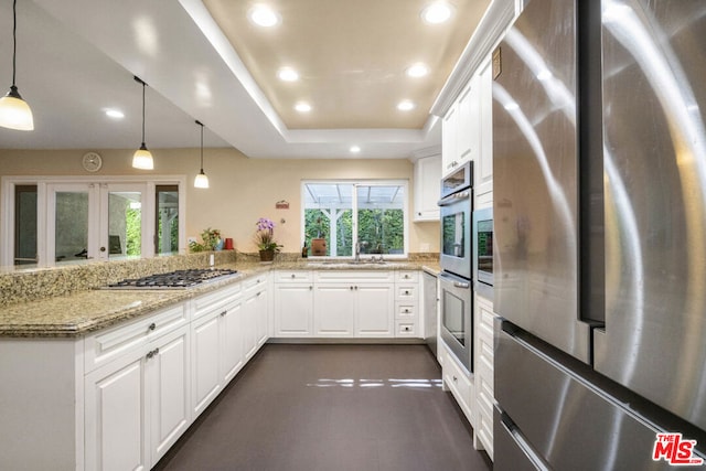 kitchen with white cabinets, stainless steel appliances, and pendant lighting