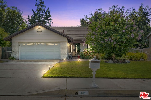 view of front facade featuring a garage and a lawn