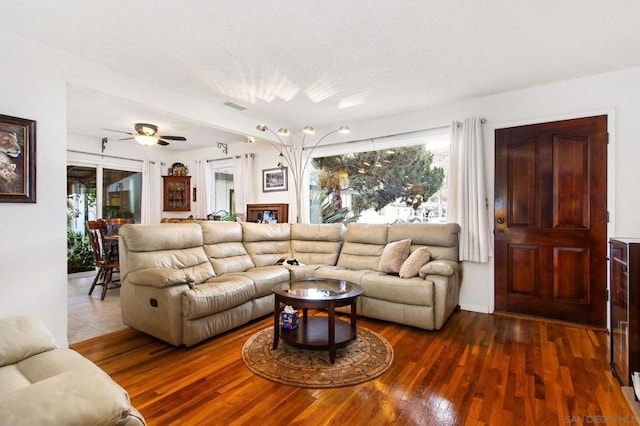 living room with ceiling fan and dark wood-type flooring