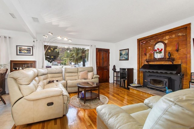 living room with a wood stove and light hardwood / wood-style flooring