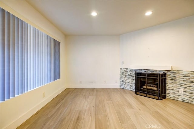 unfurnished living room featuring a fireplace and hardwood / wood-style flooring