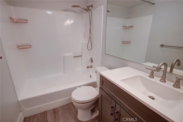 full bathroom with hardwood / wood-style floors, toilet, vanity, and shower / washtub combination