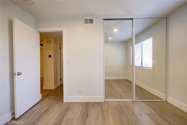 unfurnished bedroom with light hardwood / wood-style floors and a closet