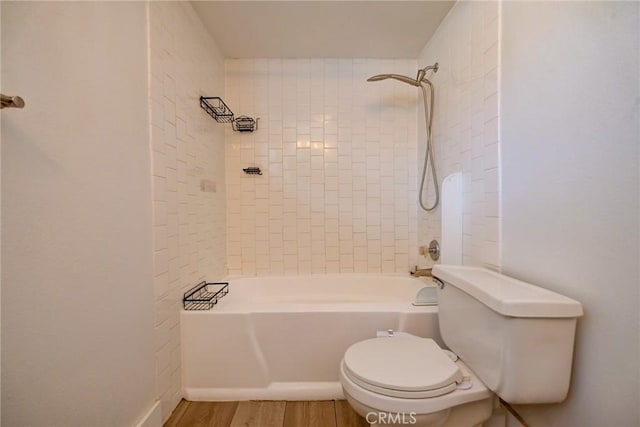 bathroom featuring toilet, tiled shower / bath, and hardwood / wood-style flooring