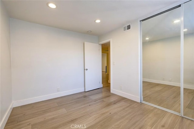 unfurnished bedroom with light hardwood / wood-style floors and a closet