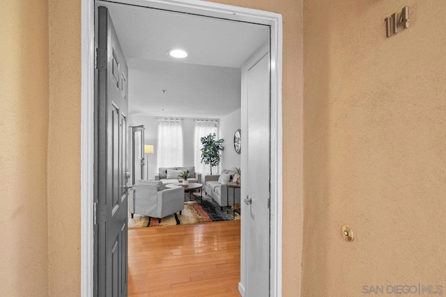 corridor with hardwood / wood-style flooring