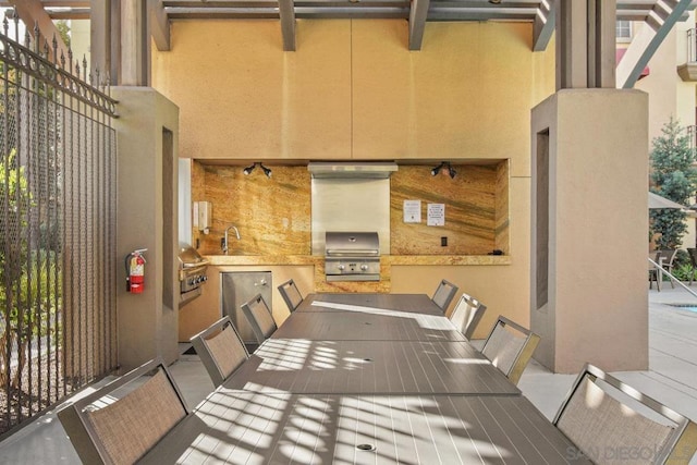 view of patio featuring exterior kitchen, sink, and a grill