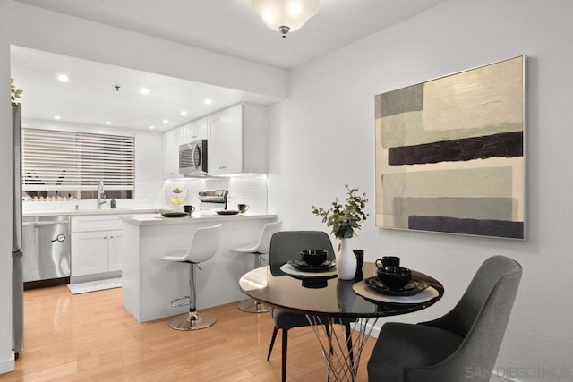 dining area with light hardwood / wood-style floors and sink