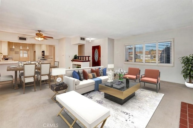 carpeted living room featuring ceiling fan