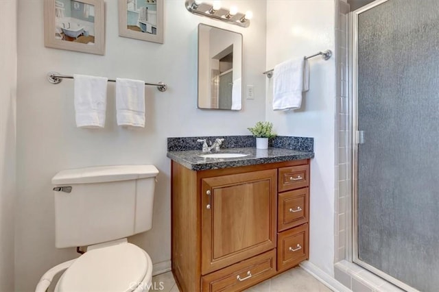 bathroom with walk in shower, vanity, tile patterned flooring, and toilet