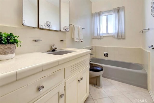 bathroom with toilet, tile patterned flooring, a bathtub, and vanity