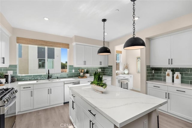 kitchen featuring white cabinets, dishwashing machine, sink, and a kitchen island