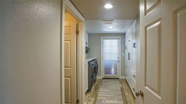 interior space with light hardwood / wood-style floors and independent washer and dryer