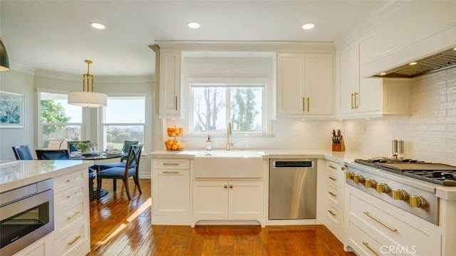 kitchen with appliances with stainless steel finishes, decorative backsplash, white cabinets, and sink