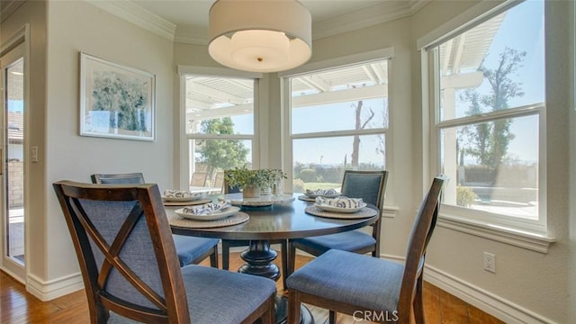 dining space with crown molding and hardwood / wood-style flooring