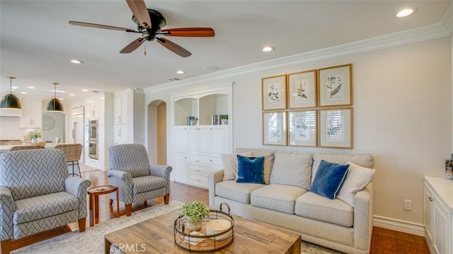 living room with ceiling fan, crown molding, and light hardwood / wood-style flooring