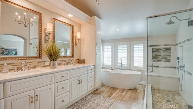 bathroom featuring hardwood / wood-style flooring, vanity, independent shower and bath, and a notable chandelier