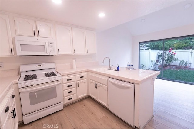 kitchen featuring sink, white appliances, light hardwood / wood-style flooring, white cabinetry, and kitchen peninsula