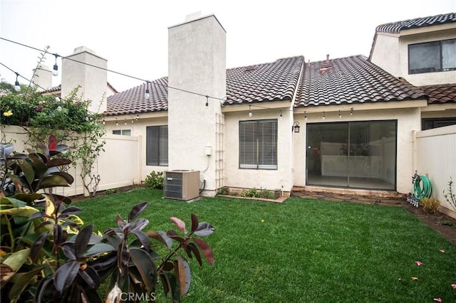 back of house with a lawn and central air condition unit