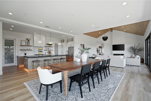 dining area with wooden ceiling, light hardwood / wood-style flooring, and high vaulted ceiling