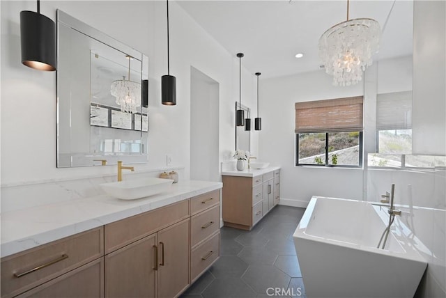 bathroom featuring a chandelier, tile patterned flooring, a tub to relax in, and vanity