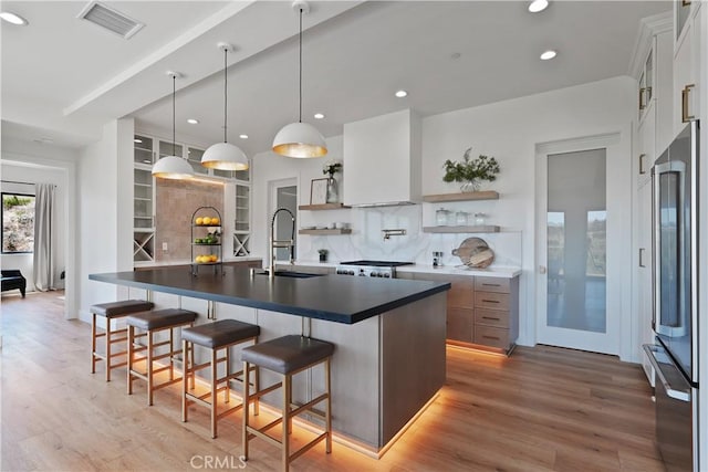 kitchen featuring a large island, tasteful backsplash, hanging light fixtures, white cabinets, and sink