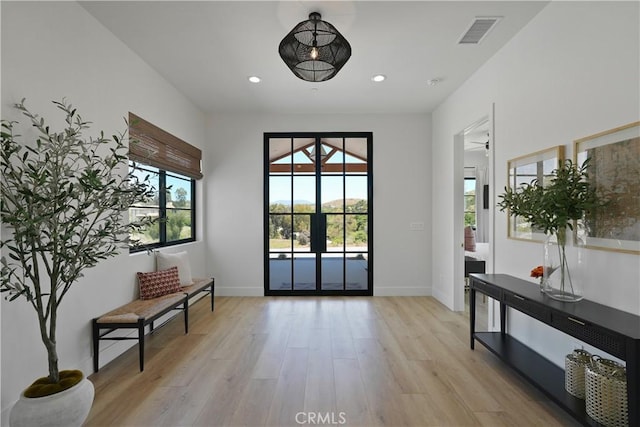 doorway to outside featuring light wood-type flooring, ceiling fan, and french doors