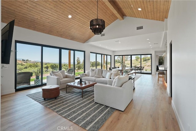 living room featuring high vaulted ceiling, beam ceiling, a notable chandelier, and light wood-type flooring