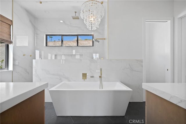 bathroom with a tub, tile patterned floors, vanity, and a notable chandelier