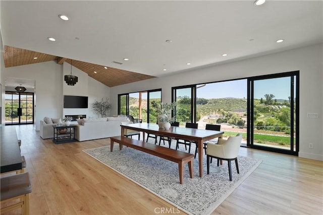 dining area featuring wood ceiling, beamed ceiling, light hardwood / wood-style floors, a chandelier, and high vaulted ceiling