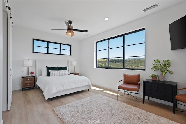 bedroom with ceiling fan and light hardwood / wood-style flooring