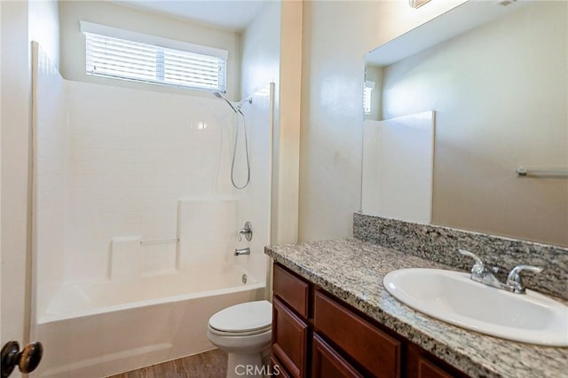 full bathroom featuring toilet, bathing tub / shower combination, hardwood / wood-style floors, and vanity