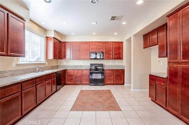 kitchen with light stone counters, sink, light tile patterned floors, and black appliances