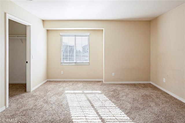 unfurnished bedroom featuring light carpet and a closet