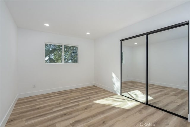 unfurnished bedroom featuring a closet and light wood-type flooring