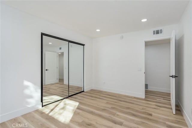 unfurnished bedroom featuring a closet and light hardwood / wood-style flooring