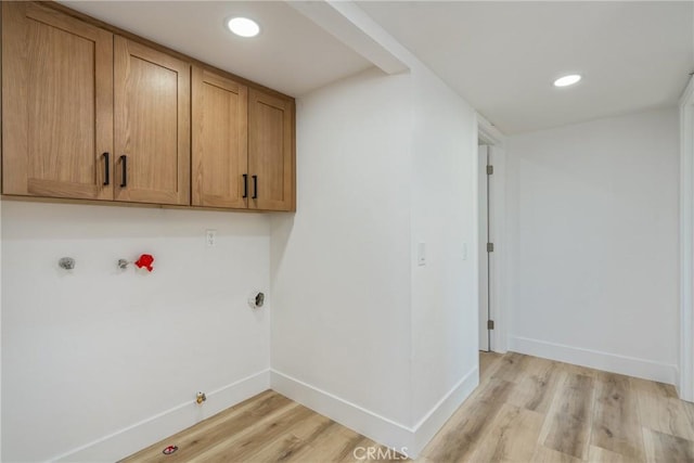 laundry area featuring cabinets, hookup for a gas dryer, light hardwood / wood-style flooring, and washer hookup