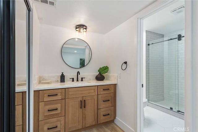 bathroom featuring toilet, hardwood / wood-style floors, an enclosed shower, and vanity