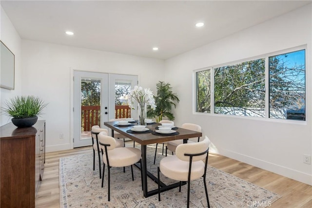 dining room with light wood-type flooring and french doors