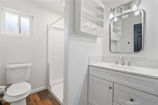 bathroom with a shower, hardwood / wood-style flooring, vanity, and toilet