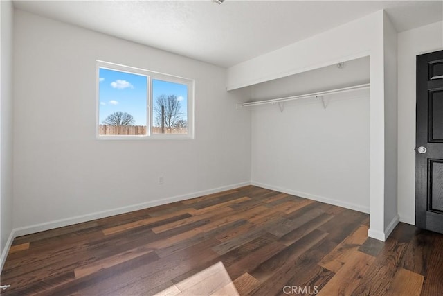 unfurnished bedroom with a closet and dark hardwood / wood-style floors