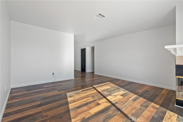 unfurnished room with dark hardwood / wood-style flooring and a multi sided fireplace