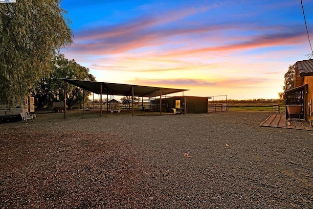 yard at dusk featuring an outdoor structure