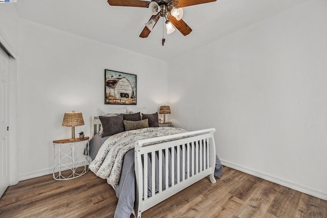 bedroom with ceiling fan, a closet, and hardwood / wood-style floors