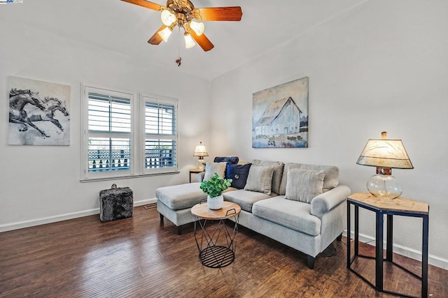 living room featuring dark wood-type flooring and ceiling fan