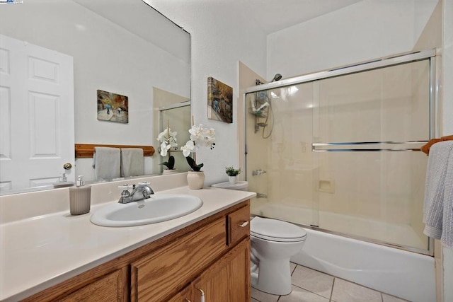 full bathroom featuring toilet, tile patterned floors, vanity, and enclosed tub / shower combo