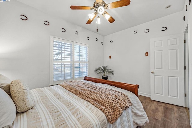 bedroom with ceiling fan and hardwood / wood-style flooring